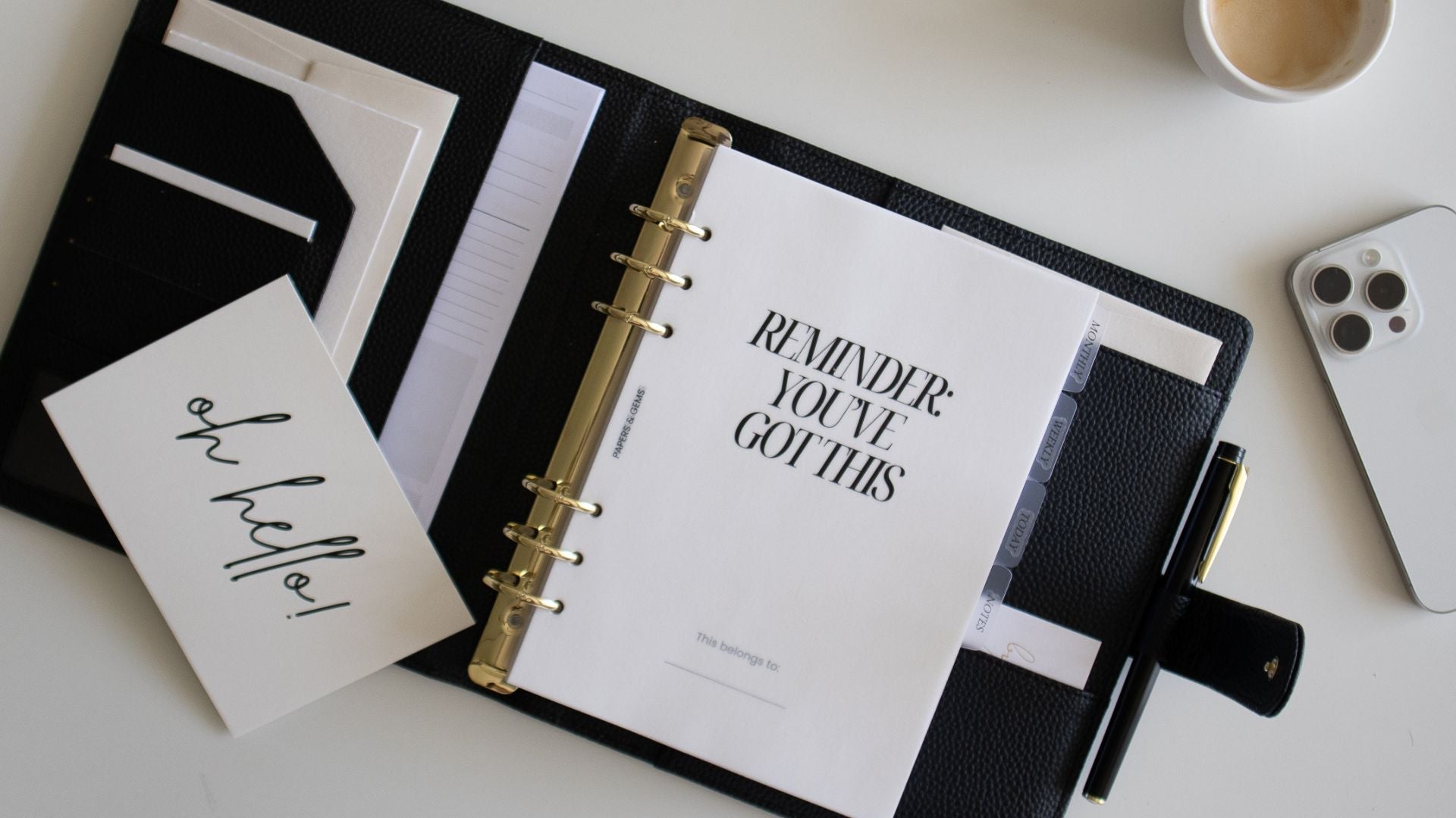 daily planner on desk with a cup of coffee and a pen