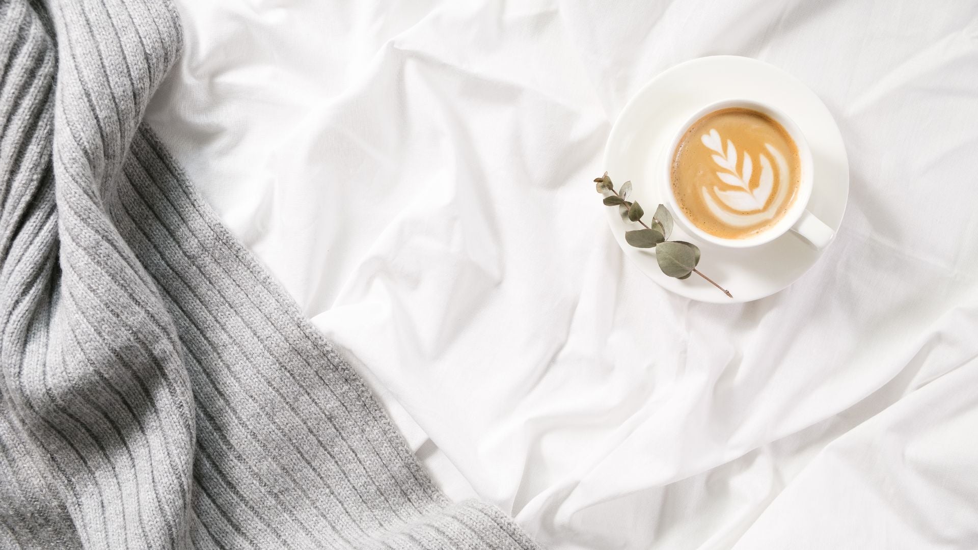 coffee cup on white bedsheets