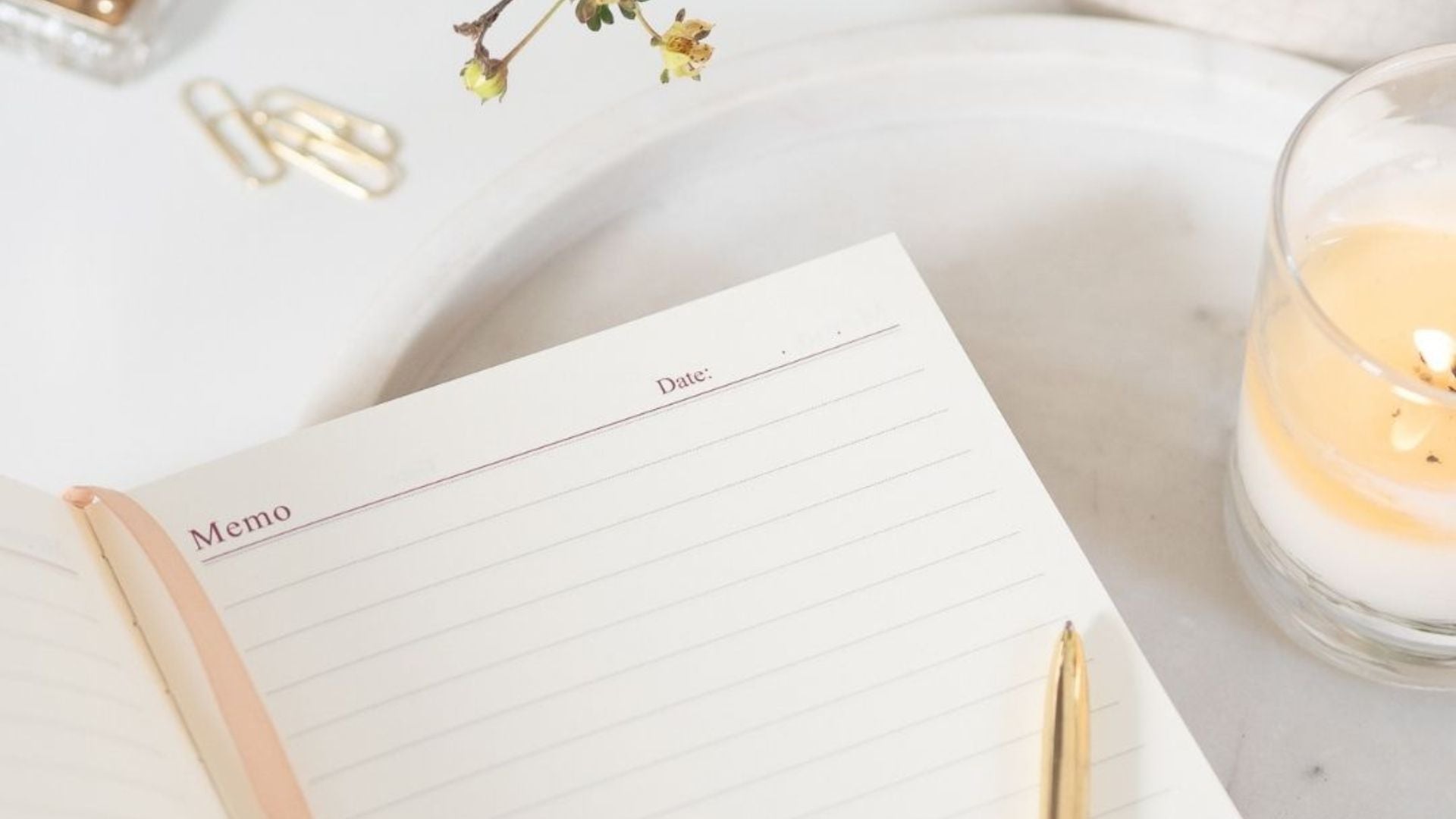 gratitude journal notebook on desk with candle and pen