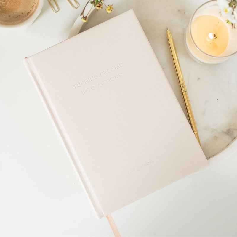 Taupe neutral notebook on desk with candle and pen